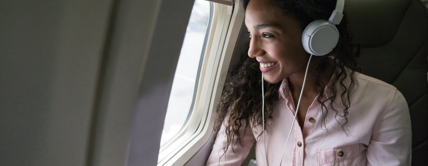 Woman wearing headphones in an airplane