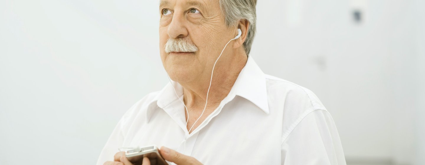 man using his iphone and earpods as a hearing aid